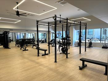 A gym with wooden floors and a variety of equipment.